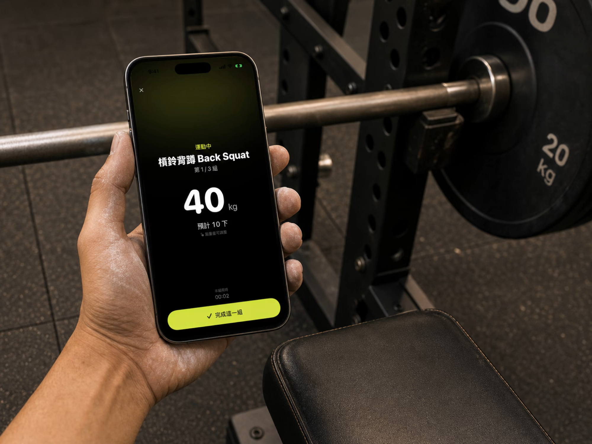 A lifter checks Reppro's focused workout view with one hand beside a squat rack